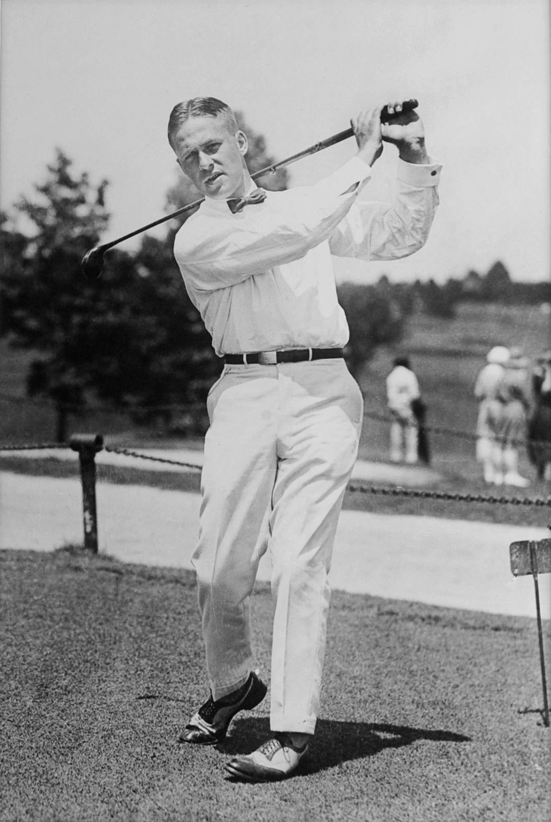 Bobby Jones at the top of his follow-through on a tee, wearing white shirt and bow tie, around 1921