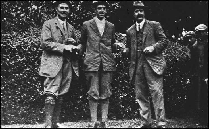 Francis Ouimet standing between Harry Vardon and Ted Ray before a hedge, 1913